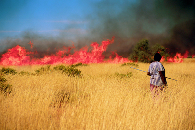 Woman Tending a Grass Fire